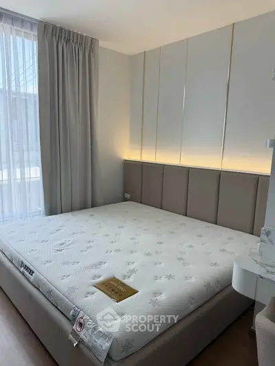 Modern bedroom with stylish paneling and large window for natural light.
