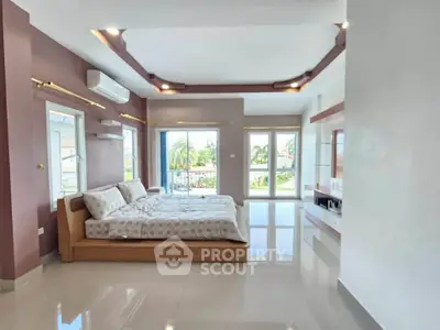 Spacious bedroom with modern design and large windows offering natural light and scenic views.