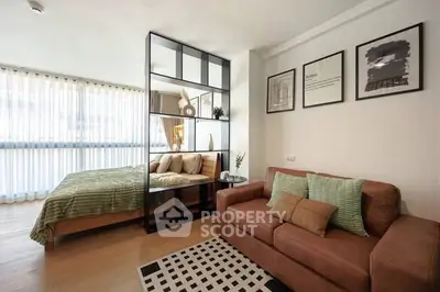 Modern studio apartment with stylish decor and open layout, featuring a cozy bed and comfortable sofa.