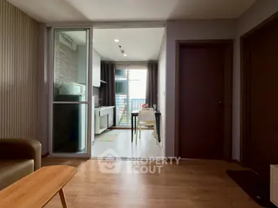 Modern apartment interior with open kitchen and dining area, featuring sleek design and natural light.