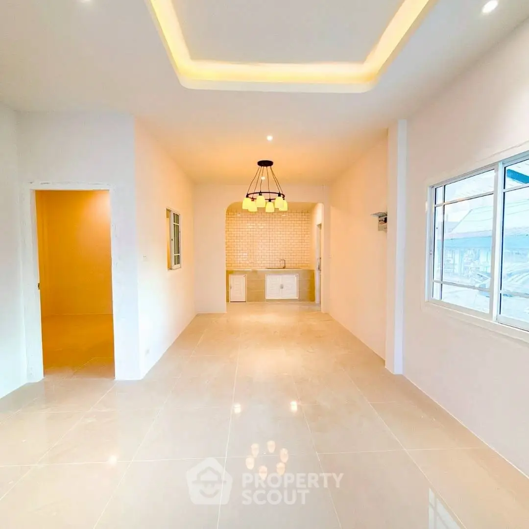 Spacious open-plan living area with modern lighting and tiled flooring