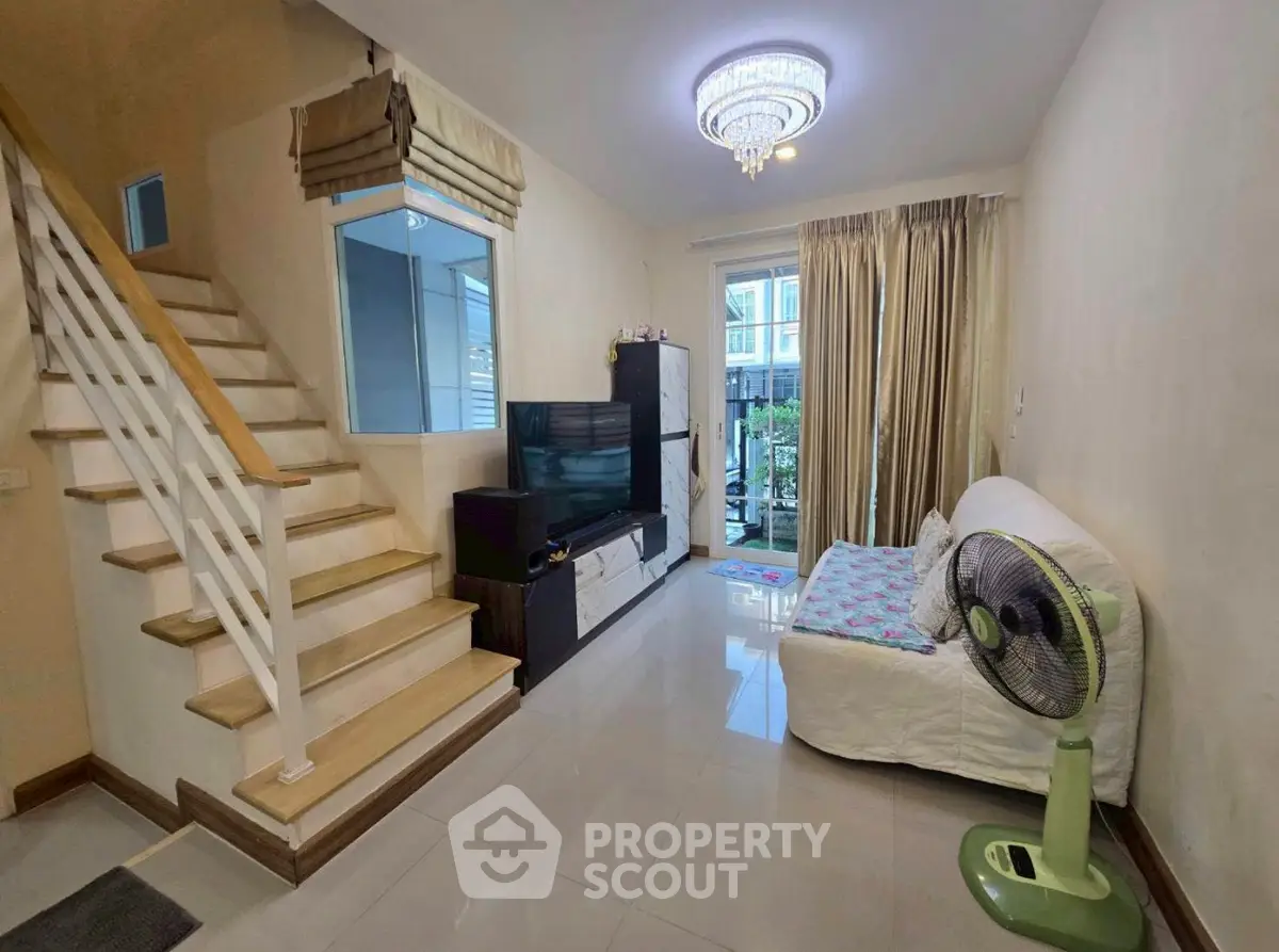 Charming living room with staircase and modern decor, perfect for cozy family gatherings.