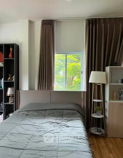 Cozy bedroom with large window and elegant decor, perfect for relaxation and comfort.