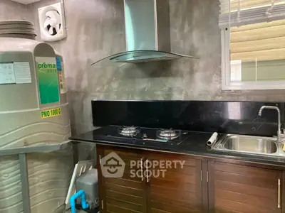 Modern kitchen with gas stove and sleek cabinetry, featuring a unique water filtration system.