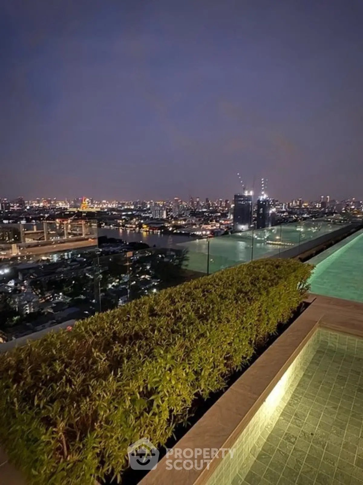 Stunning rooftop pool with panoramic city skyline view at night