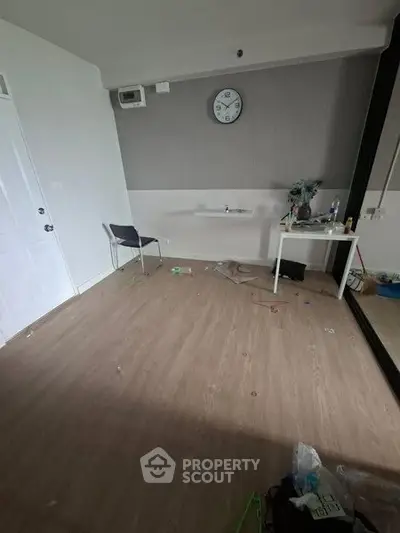 Spacious room with wooden flooring and minimal furniture, ideal for customization.