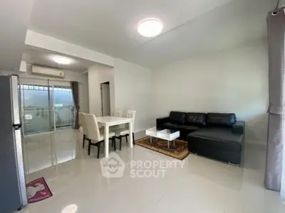 Spacious modern living room with sleek furniture and dining area in open layout.