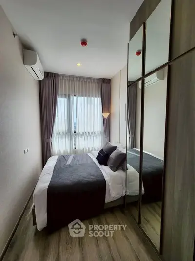 Modern bedroom with stylish decor and large mirrored wardrobe in a cozy apartment.