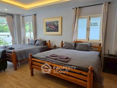 Spacious bedroom with two wooden beds and elegant decor