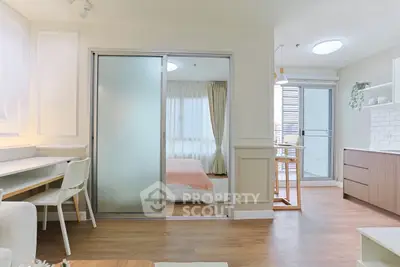 Modern open-plan apartment with sliding doors, cozy bedroom, and stylish kitchen area.