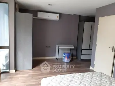 Spacious bedroom with modern furniture and air conditioning unit.