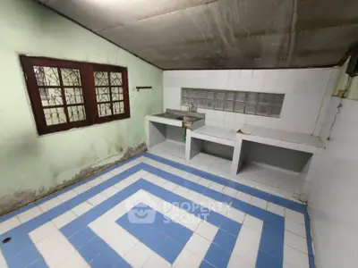 Spacious kitchen with unique tile pattern and ample counter space in a cozy home.