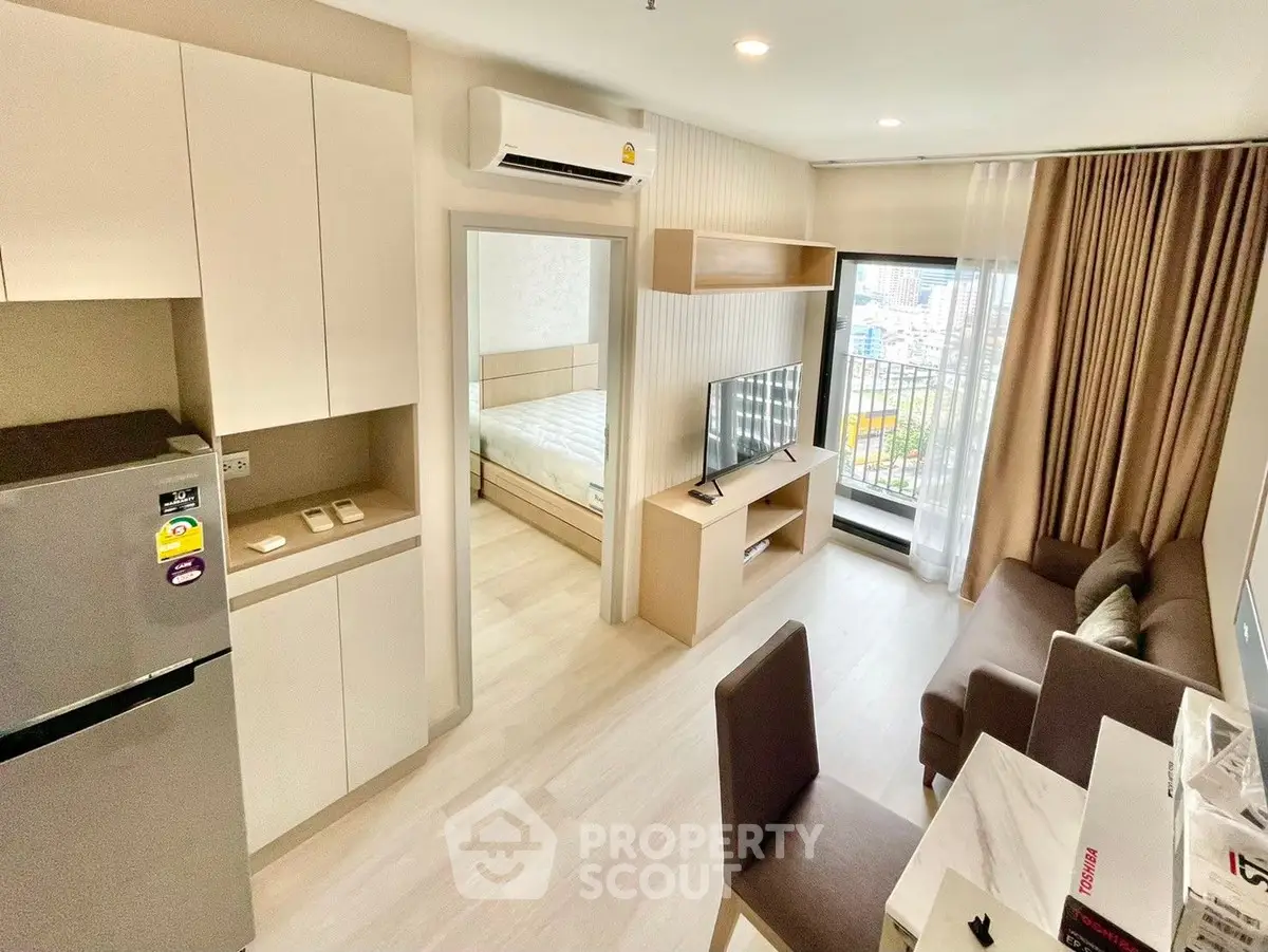 Modern apartment interior with open living room, dining area, and bedroom view.