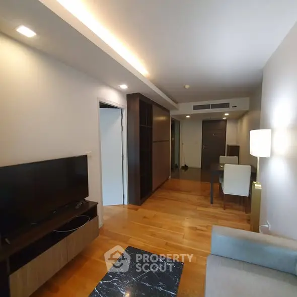 Modern living room with wooden flooring and sleek furniture in a stylish apartment.