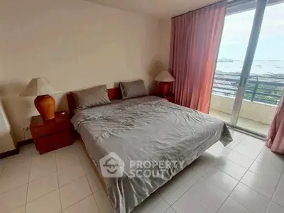 Spacious bedroom with balcony and ocean view in modern apartment