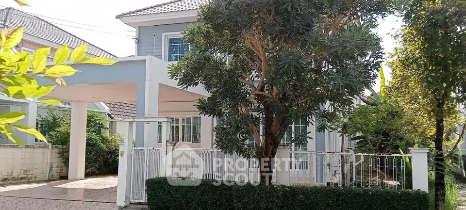 Charming two-story house with lush garden and spacious driveway in serene neighborhood.