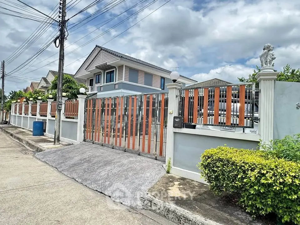Charming suburban house with gated entrance and lush greenery, perfect for family living.