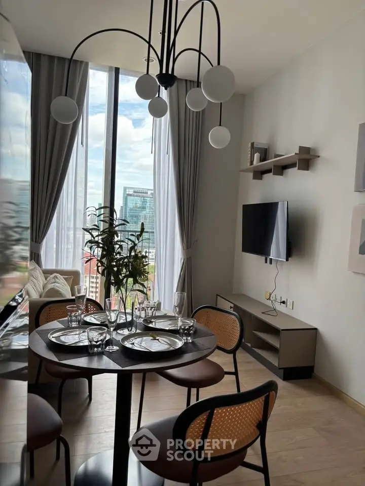 Modern living room with stylish dining area and large window view in high-rise apartment.