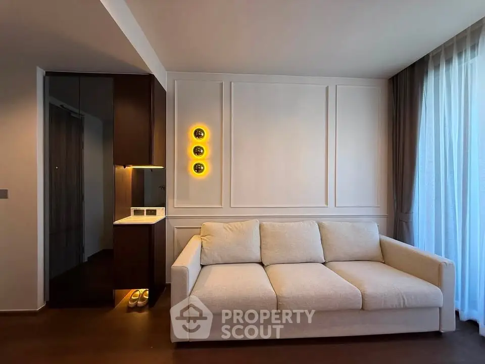 Modern living room with elegant sofa and stylish lighting, featuring floor-to-ceiling curtains for a cozy ambiance.