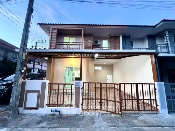 Charming two-story townhouse with modern facade and spacious driveway in a serene neighborhood.