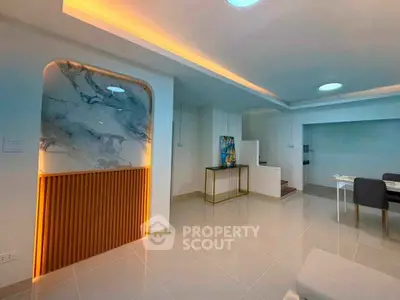 Modern living room with elegant marble accent wall and ambient lighting