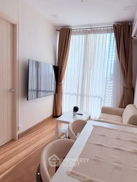 Modern living room with large TV and elegant curtains