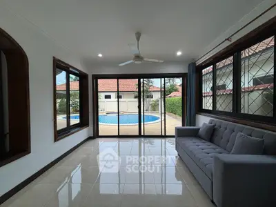 Spacious living room with pool view and modern furnishings in luxury home