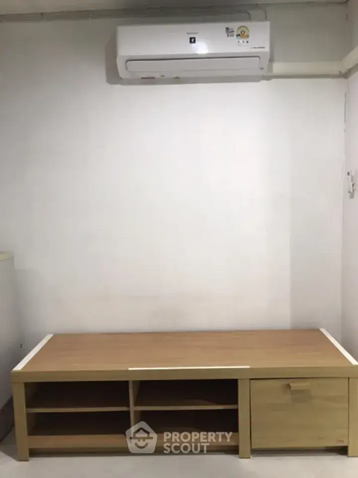 Minimalist interior with air conditioner and wooden storage bench in modern home.