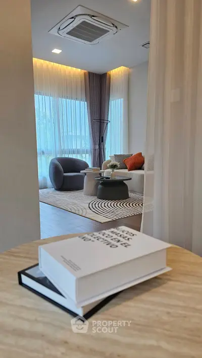 Modern living room with stylish furniture and large windows offering natural light.