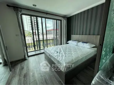 Modern bedroom with large window and city view, featuring stylish decor and natural light.