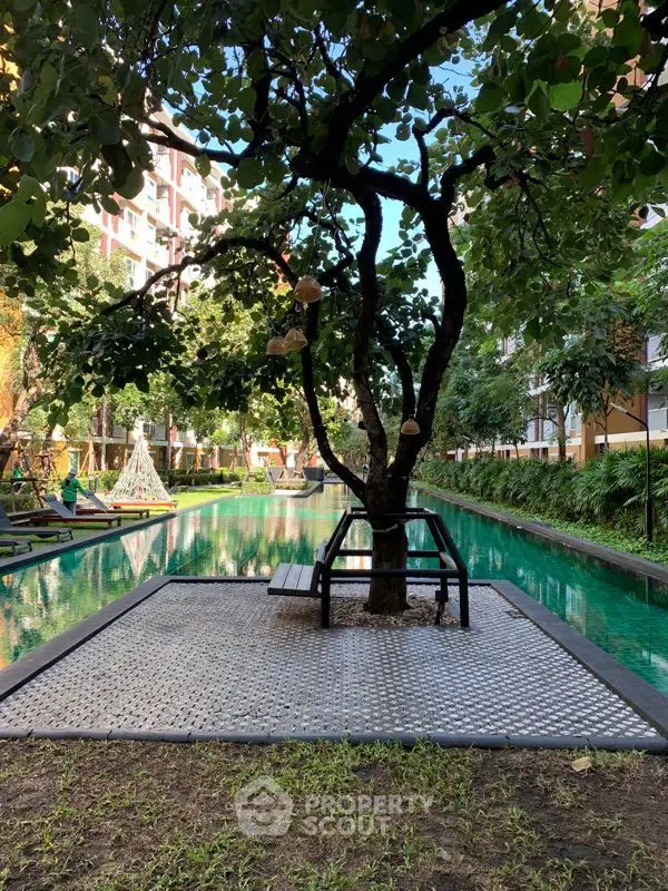 Tranquil garden oasis with a serene pool, lush greenery, and a unique tree centerpiece, ideal for peaceful living in a vibrant community.