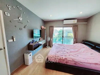 Modern bedroom with large window, stylish wall clock, and sleek furniture in a cozy home setting.