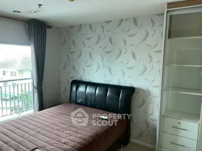 Cozy bedroom with stylish wallpaper and balcony view in modern apartment