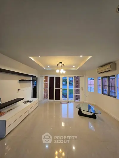 Spacious living room with modern lighting and large windows for natural light