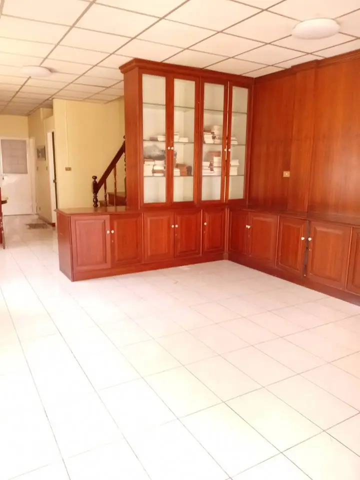Spacious room with elegant wooden cabinetry and tiled flooring, perfect for versatile use in a modern home.