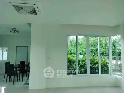 Spacious modern living room with large windows and garden view