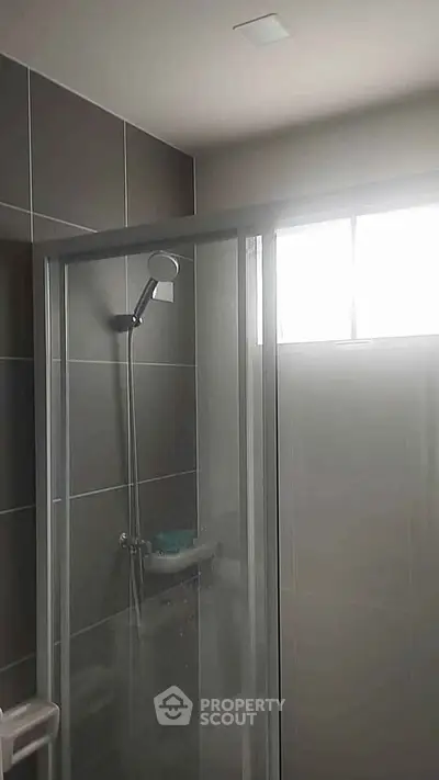 Modern bathroom with glass shower enclosure and sleek tile design.