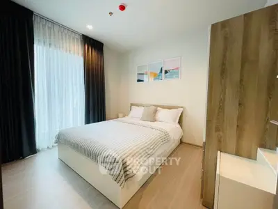 Modern bedroom with cozy decor and natural light in a stylish apartment.