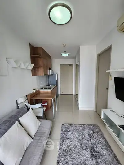 Modern living room with open kitchen in a stylish apartment, featuring sleek furniture and contemporary design.