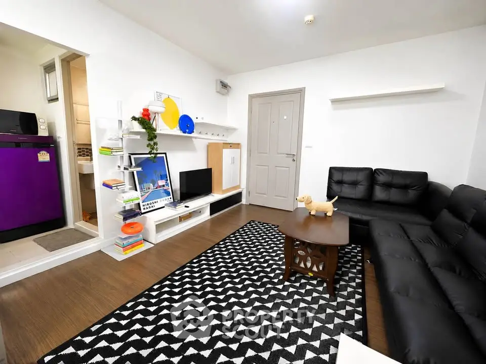 Modern living room with stylish black sofa and geometric rug