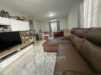 Spacious living room with modern brown leather sofa and entertainment center
