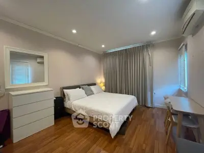 Spacious bedroom with modern decor and wooden flooring