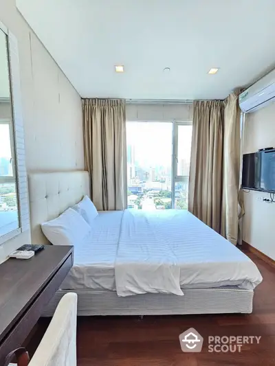 Modern bedroom with city view, featuring a comfortable bed, wall-mounted TV, and large windows.