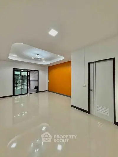 Spacious modern living room with glossy floors and vibrant accent wall