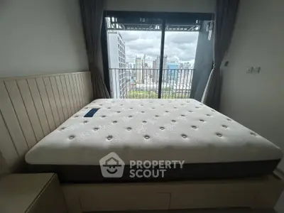 Spacious bedroom with city view and large window balcony access.