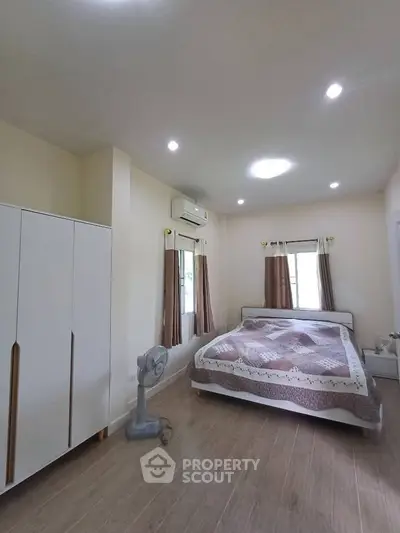 Spacious bedroom with modern decor and natural light