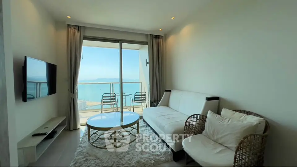 Stunning living room with ocean view, modern furniture, and floor-to-ceiling windows in a luxury apartment.