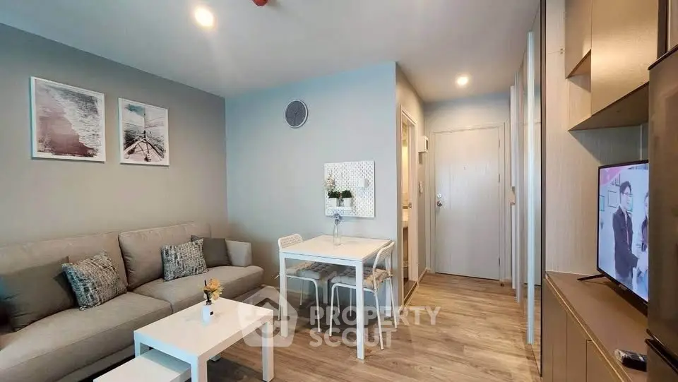 Modern living room with cozy sofa, stylish decor, and dining area in open-plan apartment.
