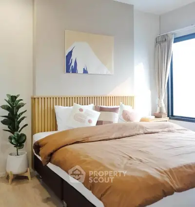 Cozy bedroom with modern decor and large window for natural light.