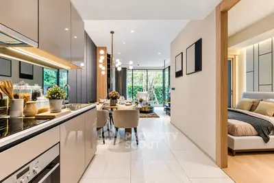 Modern open-plan kitchen and dining area with elegant decor and cozy bedroom view.